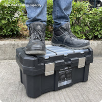 Person standing on a black toolbox with 'High load-bearing capacity' text, wearing blue jeans and black boots.